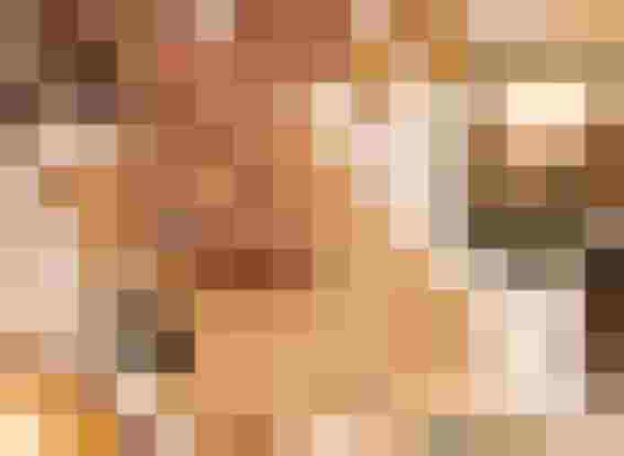 Hand schreibt Zahlen auf Papier neben Kerzen Würfeln und spirituellen Gegenständen